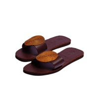 a pair of brown slide sandals on a black background