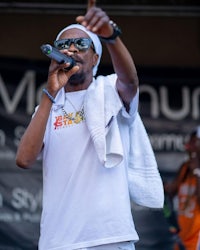 a man in a white shirt singing into a microphone