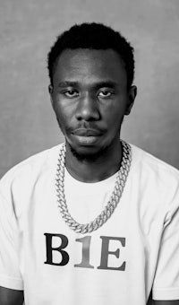 a black and white photo of a man wearing a white t - shirt